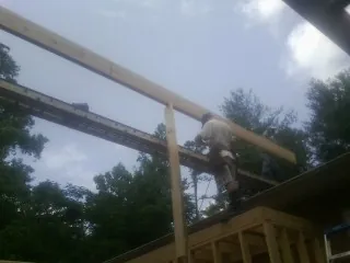 Carpenter setting a ridge beam over a new addition frame — Ice Dam Removal by Roofing Brothers in Frenchburg