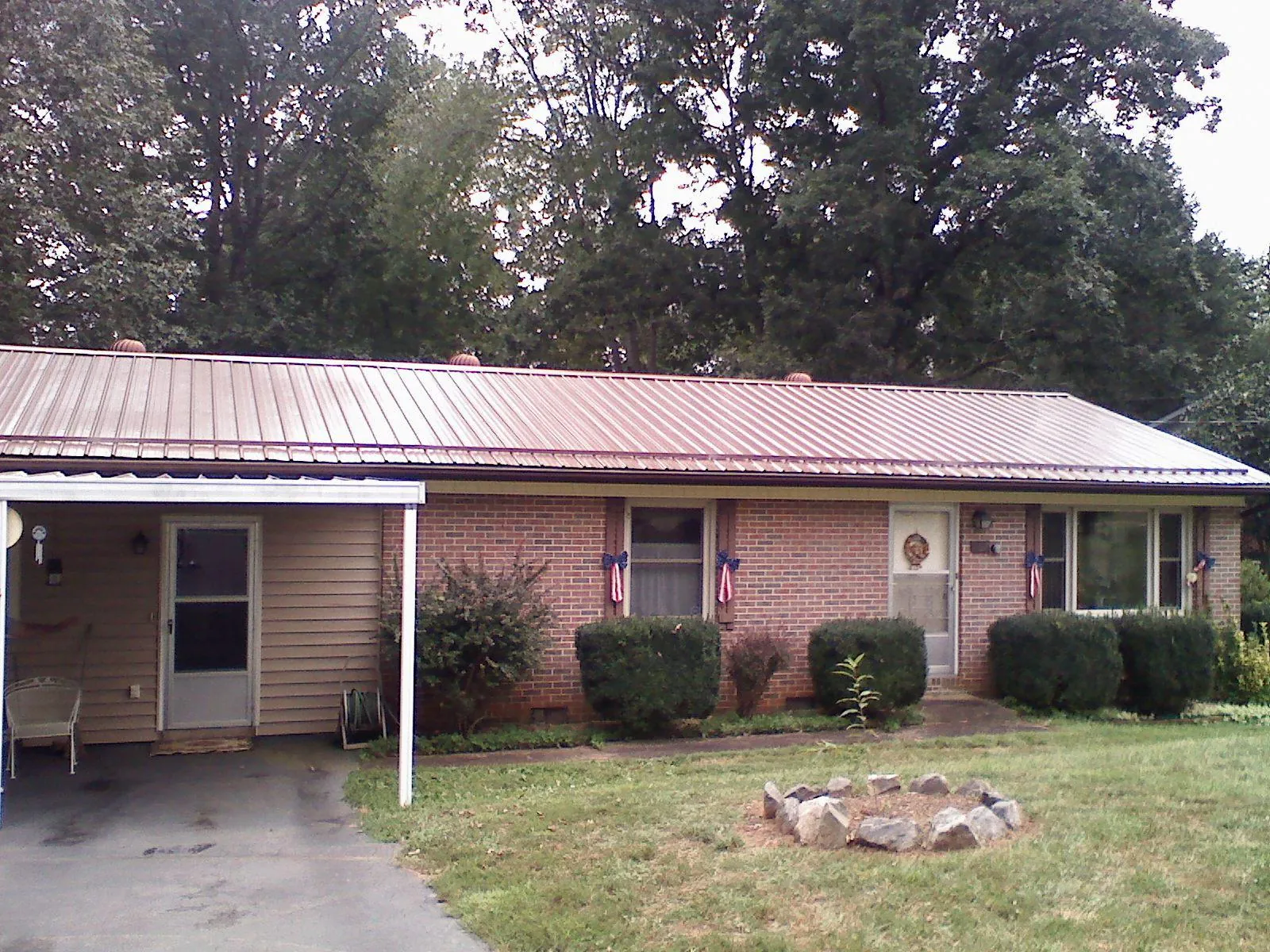 Bronze metal roof and carport on a brick ranch home — Roof Repair work by our crew in Frenchburg