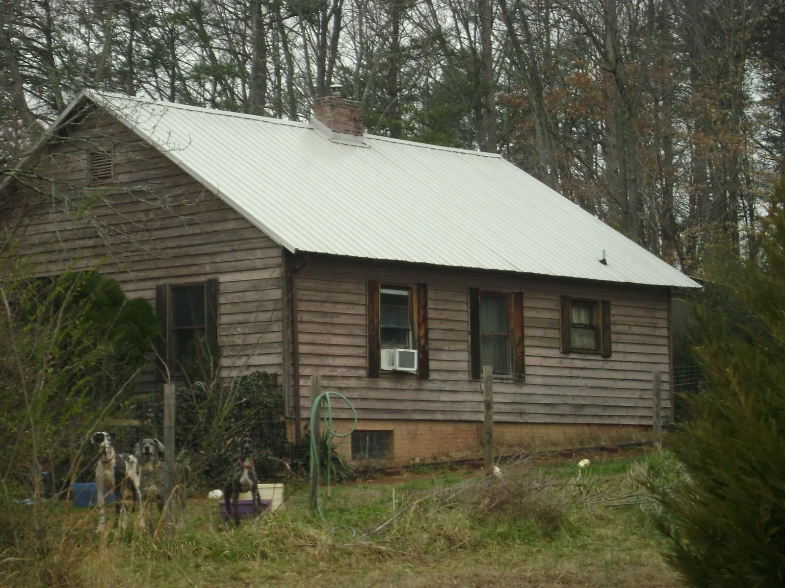 White metal roof on an old wood sided farmhouse, from a Metal Roof Installation job in Frenchburg